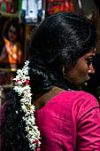 Scented garlands of fresh flowers swaying in women black hair near the Swamimalai temple. 